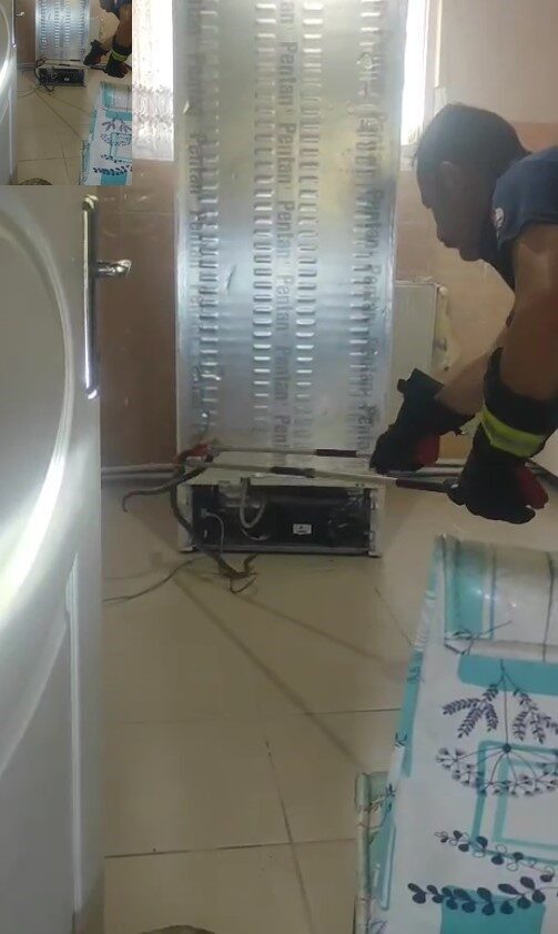 Buzdolabı motoruna giren yılanı itfaiye çıkardı