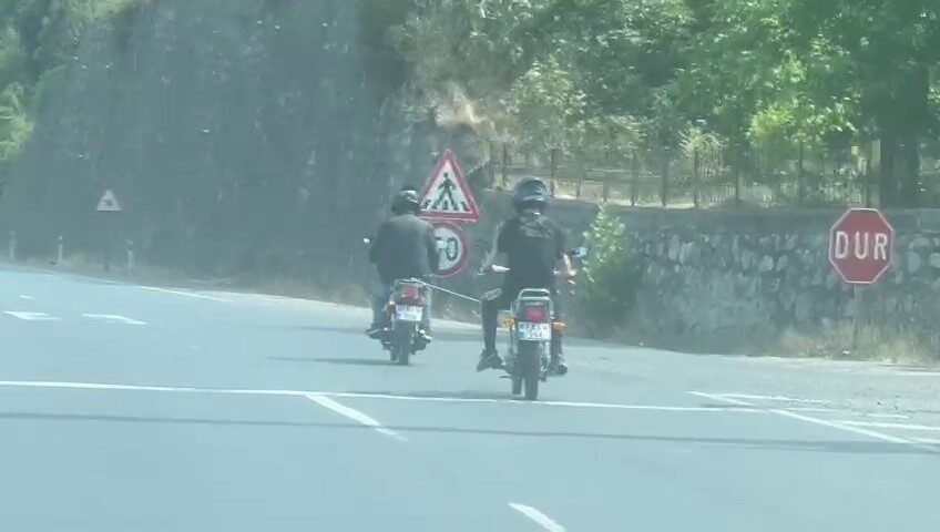 Yolda arızalanan motosiklet, başka bir motosikletliyle halata bağlanarak ilerledi