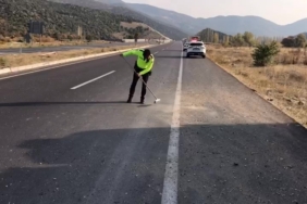 Trafik polisi cam kırıkları ve taş dökülen yolu fırçayla temizledi