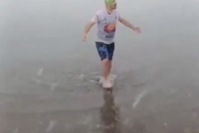 Kar altında denize girip yüzdü attı